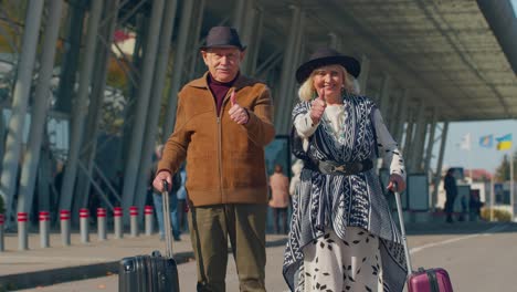 Los-Turistas-Jubilados-Mayores-Abuela-Abuelo-Levanta-El-Pulgar-Hacia-Arriba-Respuesta-Positiva-Cerca-De-La-Sala-Del-Aeropuerto