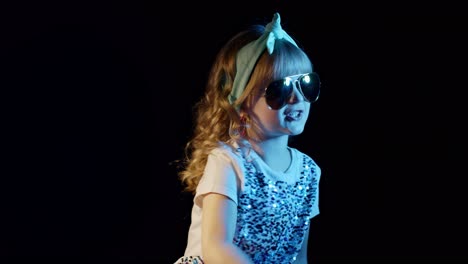 Trendiges-Mädchen-In-Futuristischer-Brille-Tanzt-Und-Hört-Musik-über-Kopfhörer-Auf-Schwarzem-Hintergrund