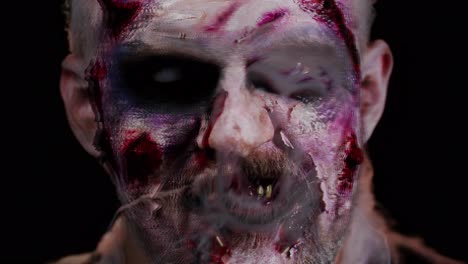 Unheimlicher-Mann-Mit-Schrecklich-Gruseligem-Halloween-Zombie-Make-up,-Der-Unter-Krämpfen-Gesichter-Macht-Und-Versucht,-Angst-Zu-Machen