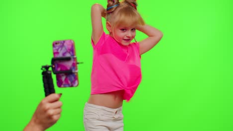 Dancing-young-little-kid-girl-blogger-record-dance-moves-at-camera-for-social-media-content-on-phone