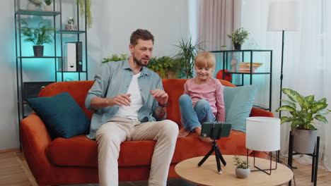 Blogger-father-and-child-kid-daughter-listening-music,-dancing,-recording-video-social-media-content