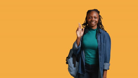 Cheerful-girl-with-hand-up-volunteering-to-tell-teacher-explanation-to-question