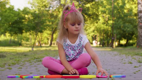 Child-girl-kid-playing-squeezing-anti-stress-pop-it-touch-screen-toys-simple-dimple-game-in-park