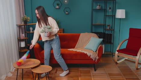 Happy-young-woman-dusting-furniture-caring-for-hygiene-using-colorful-duster-in-living-room-at-home