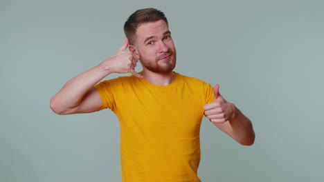 Un-Hombre-Alegre-Con-Camiseta-Mirando-La-Cámara-Haciendo-Un-Gesto-Con-El-Teléfono-Como-Dice-&quot;oye,-Llámame-De-Nuevo&quot;