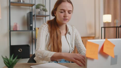 Nervous-adult-freelancer-girl-confused-by-big-routine-laptop-work-loading-indoors-at-home-office