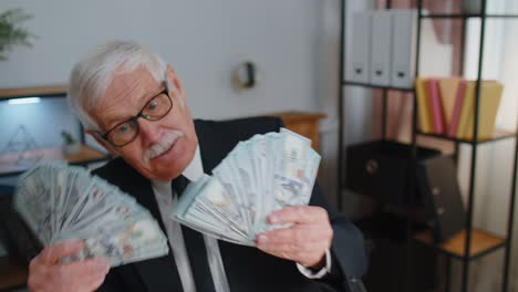 Business-man-accountant-celebrating-business-success-dancing-with-stack-of-money-dollar-cash