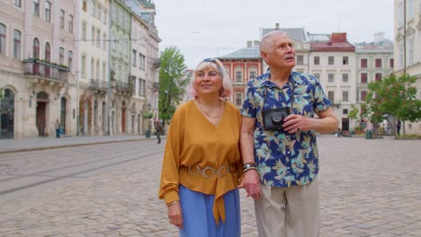Älteres-Stilvolles-Touristenpaar,-Mann,-Frau,-Großmutter,-Großvater,-Spazieren-Entlang-Der-Straße-In-Der-Altstadt