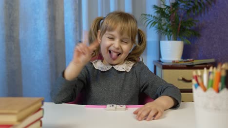 Niña-Mirando-Una-Cámara-Web-Haciendo-Videollamadas,-Estudiando-Lecciones-En-Casa,-Sonriendo-Mostrando-La-Lengua