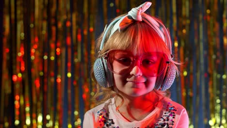 Portrait-of-trendy-stylish-girl-looking-at-camera,-smiling,-child-kid-in-neon-light-at-disco-club