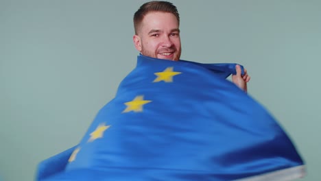 Mann-Schwenkt-Die-Flagge-Der-Europäischen-Union,-Lächelt-Und-Jubelt-Demokratischen-Gesetzen,-Menschenrechten-Und-Freiheiten-In-Europa-Zu
