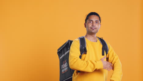 Portrait-of-confident-man-with-thermal-backpack-crossing-arms,-studio-background