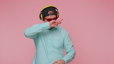 Cheerful-attractive-man-listening-music-via-headphones-and-dancing-disco-fooling-around-having-fun