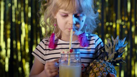 Trendy-stylish-child-kid-with-pineapple-fruit-drinking-juice-in-futuristic-club-with-neon-light