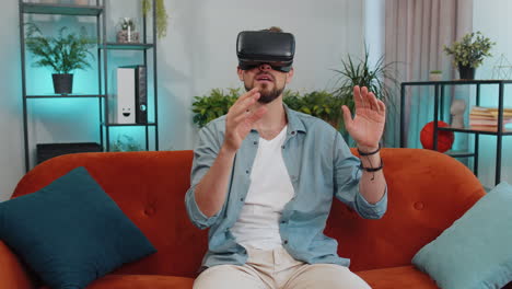 Man-using-virtual-reality-futuristic-technology-headset-to-play-simulation-3D-video-game-at-home