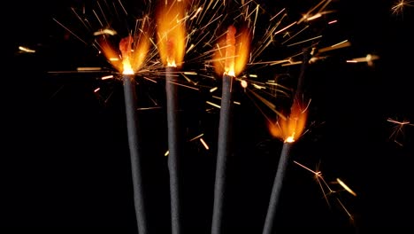 Bengal-fires,-New-Year-sparkler-candles,-sparkling-lights-burning-on-a-black-background,-slow-motion