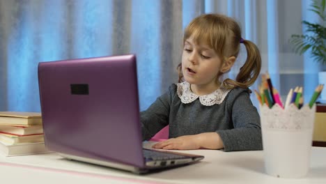 Niña-Escolar-Aprendiendo-Lecciones,-Educación-A-Distancia-En-Casa-Sentada-En-La-Mesa-Usando-Una-Computadora-Portátil