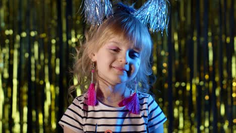 Trendy-stylish-girl-wears-pink-sunglasses,-looking-at-camera,-smiling-in-neon-light-at-disco-club