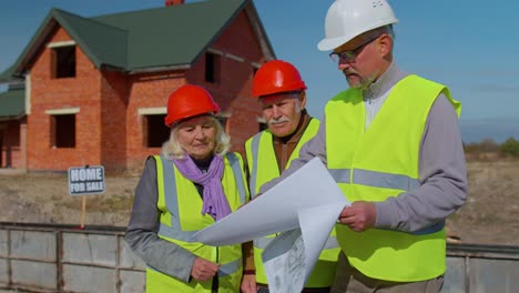 Agente-Inmobiliario-Vendiendo-Casa-Nueva-A-Abuela-Mayor,-Mostrando-Planos-De-Construcción