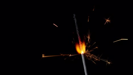 Bengal-fire,-New-Year-sparkler-candle,-sparkling-lights-burning-on-a-black-background,-slow-motion