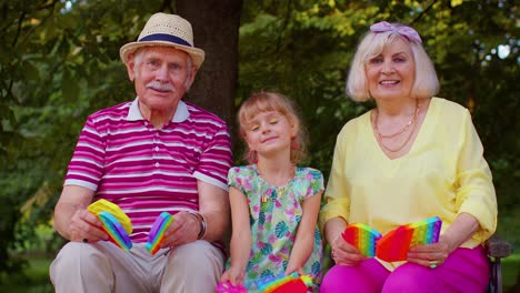 Abuelo-Sonriente-Con-Nieta-Jugando-A-Apretar-Un-Juego-De-Juguetes-Antiestrés