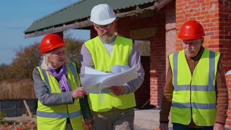 Arquitecto-Con-Ingenieros-Civiles-Senior-Discutiendo-El-Trabajo-Del-Proyecto-Con-El-Plano-De-La-Construcción-De-La-Casa.