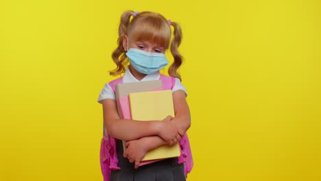 Una-Niña-Pequeña-Y-Poco-Saludable-Con-Una-Máscara-Médica-Protectora,-Parada-Con-Libros-Y-Luciendo-Cansada