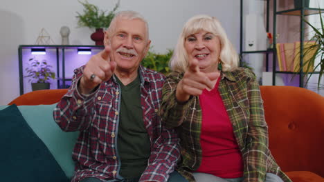 Abuelos-De-La-Familia-Mayor-Hombre-Mujer-Sonriendo-Con-Entusiasmo-Y-Apuntando-A-La-Cámara,-Eligiendo-Al-Afortunado-Ganador