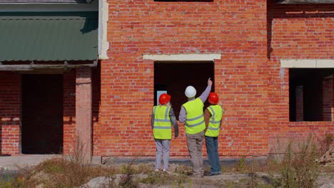 Equipo-De-Especialistas-Que-Se-Ocupan-Del-Proyecto-De-Construcción-De-Bienes-Raíces-De-Casas-Modernas-Con-Un-Ingeniero-Civil-Senior