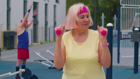 Ältere,-Reife-Frau,-Großmutter-Beim-Gewichtheben-Training-Mit-Hanteln-Auf-Dem-Spielplatz