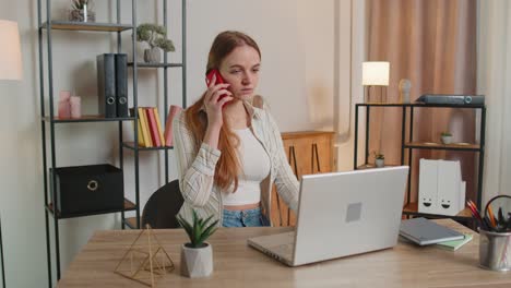 Young-woman-using-laptop-computer-sitting-on-sofa-working,-online-shopping-from-home-office