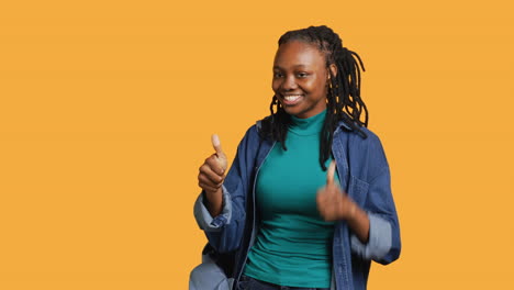 Happy-girl-doing-thumbs-up-hand-gesturing,-studio-background