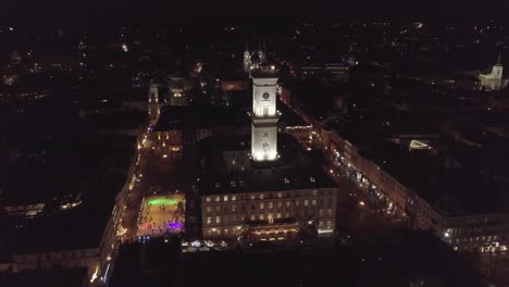 Arial-city-Lviv,-Ukraine-Rynok-square,-Town-Hall,-Christmas-Fair,-People-skate-on-ice-skating-rink