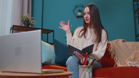 Young-woman-teacher-freelancer-consult-student-by-laptop-use-modern-tech-for-elearning-at-home-room