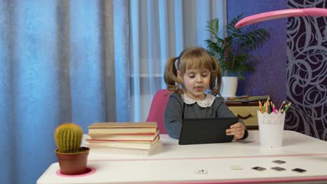 Child-schoolgirl-learning-lessons,-distance-education-at-home-sitting-at-table-using-laptop-computer