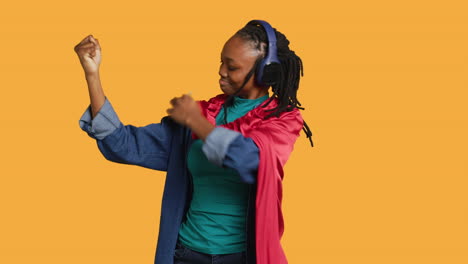 Woman-wearing-cloak-posing-as-hero-in-costume-kissing-biceps,-studio-background