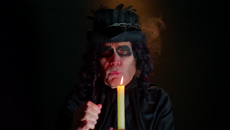 Siniestro-Anciano-Disfrazado-De-Carnaval-De-Brujo-De-Halloween-Sopla-Humo-De-La-Boca,-Tratando-De-Asustar