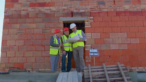 Real-estate-agent-selling-new-house-to-senior-grandmother-grandfather,-showing-building-blueprints