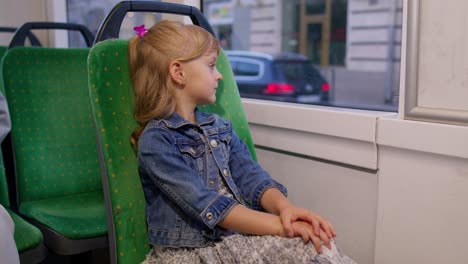 Porträt-Eines-Mädchens,-Das-Im-Modernen-öffentlichen-Bus-Oder-In-Der-Straßenbahn-Mitfährt-Und-Aus-Dem-Fenster-Schaut