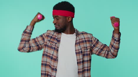 Sporty-african-american-man-working-out-pumping-up-arm-muscles-lifting-dumbbells-practicing-pilates