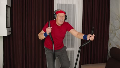 Healthy-elderly-senior-grandfather-model-exercising-sport-workout-on-orbitrek-in-room-at-home