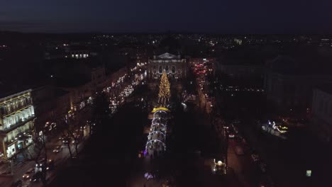 Arial-view-of-Lviv-Christmas-tree-near-Opera-house,-Festive-lights,-and-Fair-market-on-winter-night