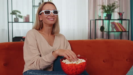 Mujer-Sentada-En-El-Sofá-Comiendo-Palomitas-De-Maíz-Y-Viendo-Interesantes-Series-De-Televisión,-Juegos-Deportivos-En-Línea-En-Casa