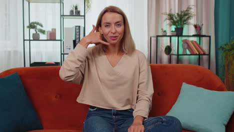 Mujer-Joven-Mirando-La-Cámara-Publicitaria-Haciendo-Un-Gesto-Telefónico-Como-Dice-&quot;oye,-Llámame-A-Casa&quot;