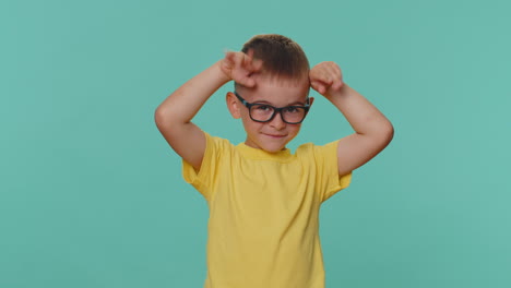 Encantador-Y-Gracioso-Niño-Pequeño-Sonriendo-Amigable,-Haciendo-Orejas-De-Conejo-En-La-Cabeza,-Engañando-Jugando