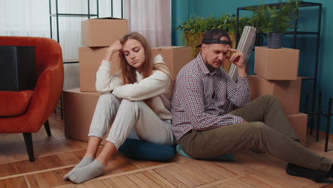 Sad-married-couple-on-floor-near-cardboard-boxes,-divorce,-long-relocation,-bankruptcy,-bank-debt
