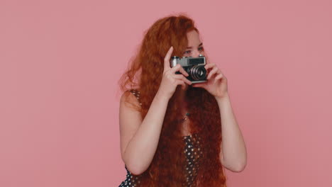 Redhead-young-woman-tourist-photographer-taking-photos-on-retro-camera-and-smiling,-holiday-vacation