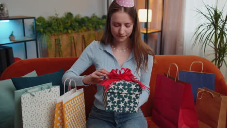 Una-Joven-Feliz-Sostiene-Una-Caja-De-Regalo-De-Cumpleaños-Con-Cinta,-Celebrando-Una-Fiesta,-Abriendo-Un-Regalo-En-Casa