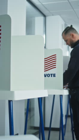 Portrait-of-female-soldier,-United-States-of-America-elections-voter.-Woman-in-camouflage-uniform-stands-in-polling-station-and-looks-at-camera.-Background-with-voting-booths.-Concept-of-civic-duty.