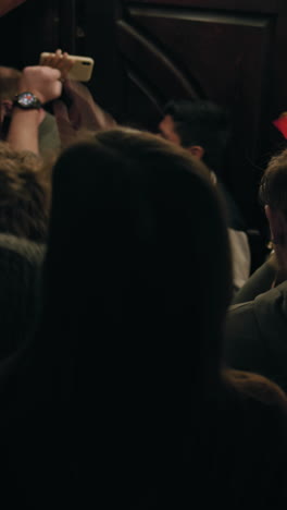 Vertical-shot-of-friends-together-go-down-stairs-in-sports-pub-hallway.-People-gathered-to-cheer-favorite-team-competing-in-important-tournament.-Supporters-come-to-watch-live-match-broadcast.